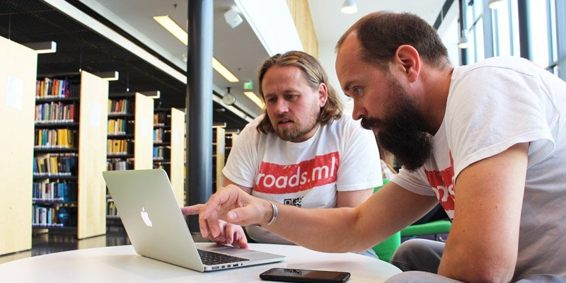 Antti Mattila ja Jussi-Pekka Martikainen katsovat kannettavaa tietokonetta valoisassa kirjastossa. 