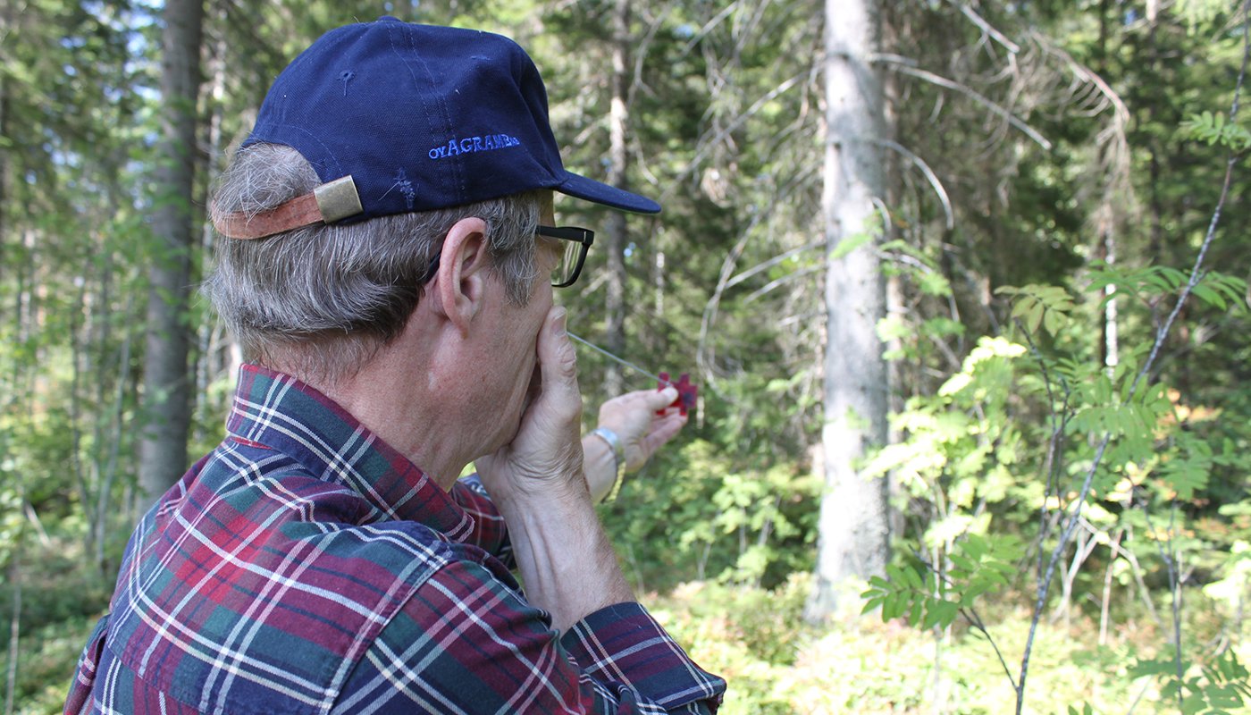 Kari Vääränen mittaa metsää relaskoopilla.