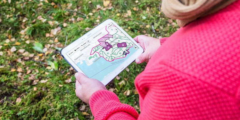 Henkilö tutkii Metsään.fi-palvelua tabletilla.
