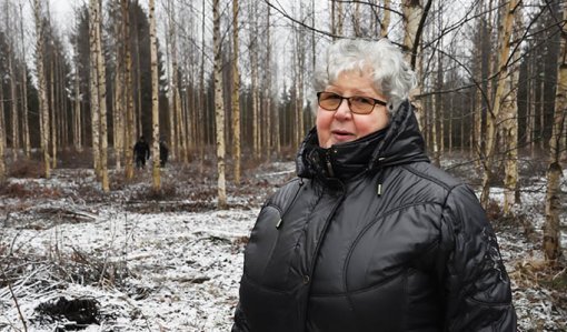 Kaisa Kolehmainen ja taustalla pellolle kasvanut koivikko.