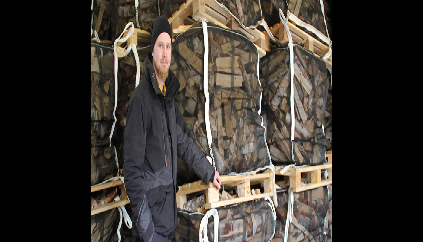 Esa-Pekka Penttilä polttopuusäkkien vieressä.