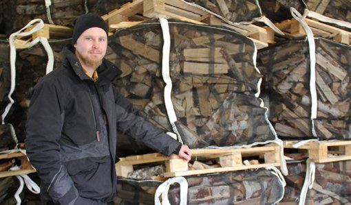 Esa-Pekka Penttilä polttopuusäkkien vieressä.