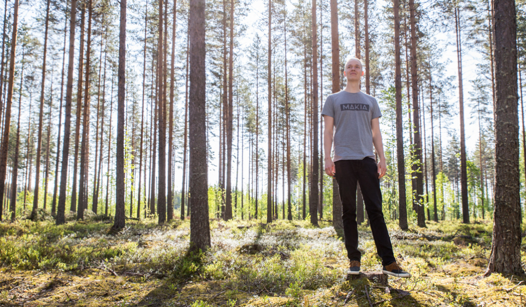 Miikka Kotilainen kuvattuna mäntyvaltaisessa talousmetsässä. 