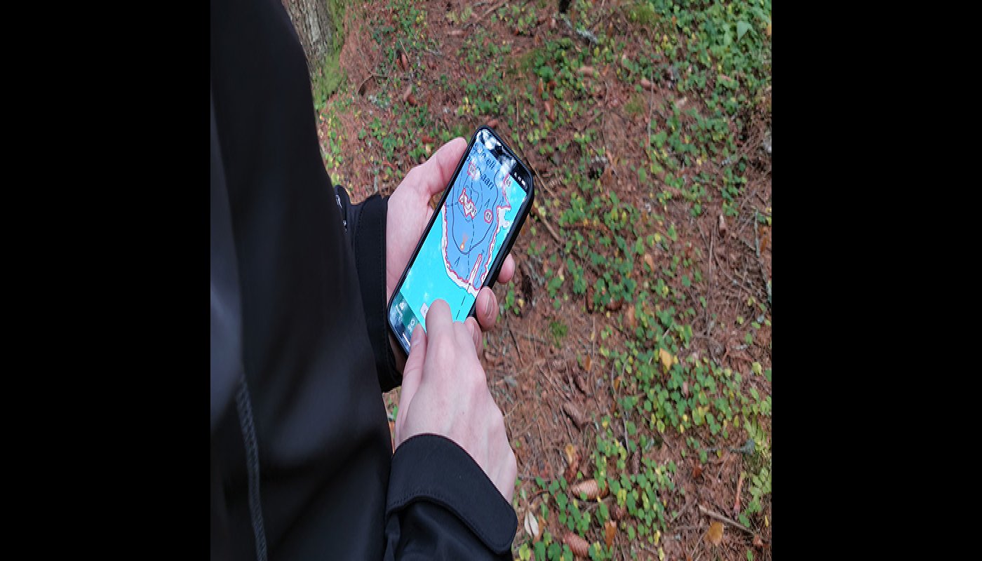 Kuvassa henkilö katsoo kännykältä karttaa. 