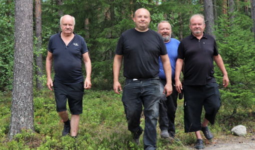 Reijo, Toni, Jani ja Mika Peräkangas kävelevät rinnakkain metsässä.