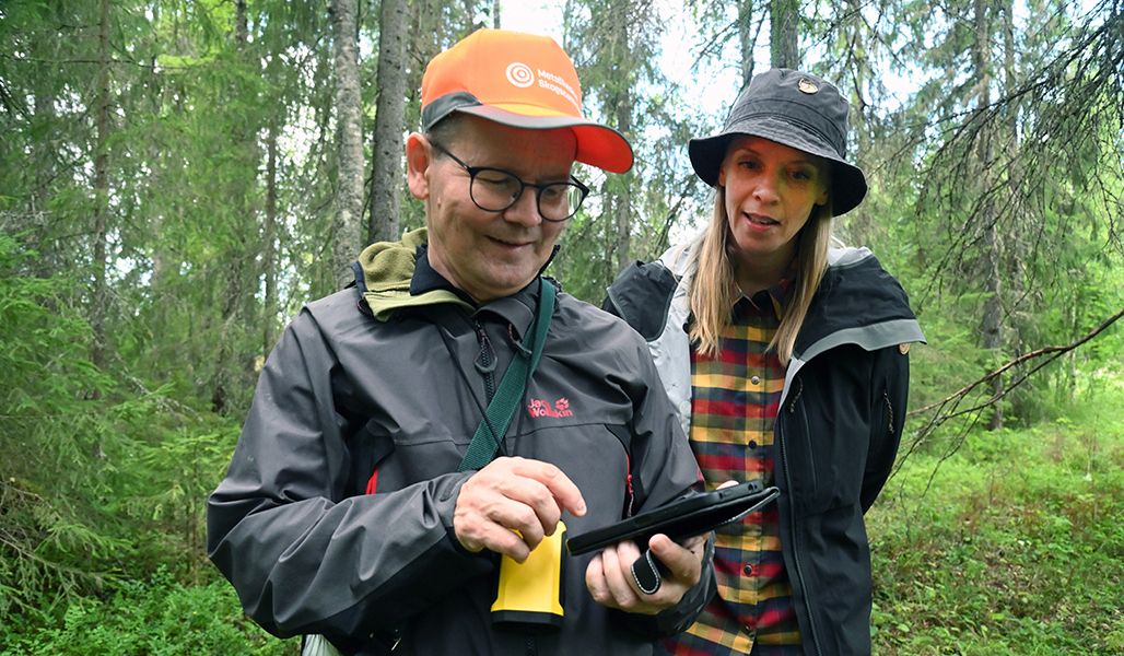 Juha Niemi ja Miia Saarimaa katsovat Niemen kädessä olevaa puhelinta ja tietoja sieltä. 