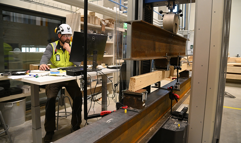 Pasi Eskelinen seuraa puun taivutustestiä laboratoriossa. 