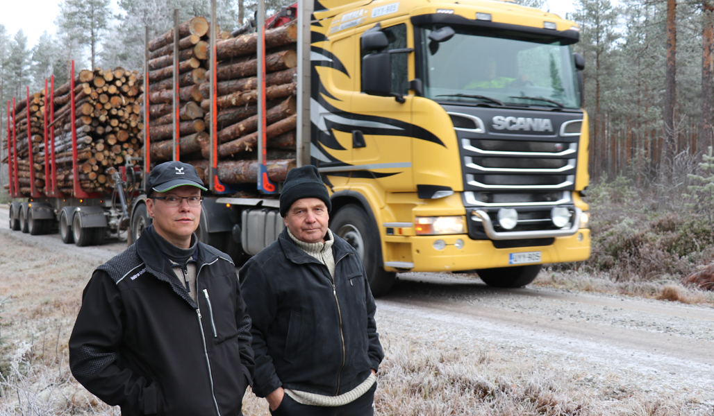 Kuvassa ovat Sammuksen tiekunnan puheenjohtaja Jouni Mäkiluoma (vas.) ja hoitokunnan jäsen Juhani Kosola. Heidän takanaan on tukkirekka.