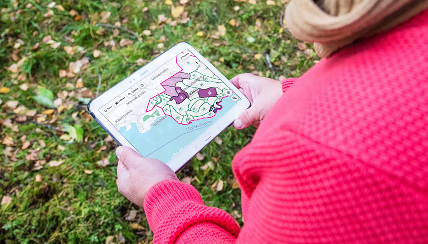 Henkilö katsoo tabletilta Metsään.fi-palvelun karttaa. 
