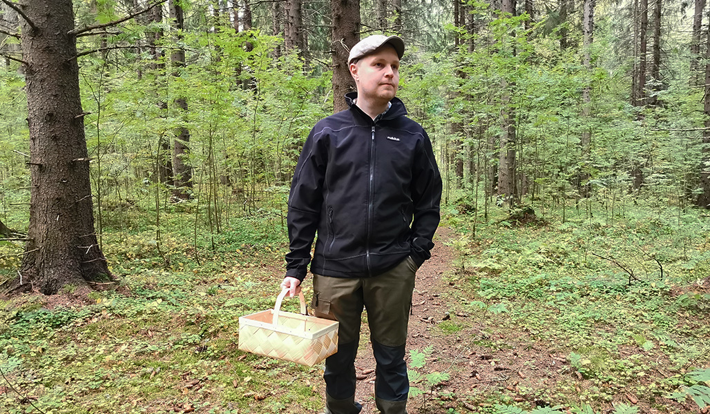 Jarno Kinnunen metsässä sienikorin kanssa. 