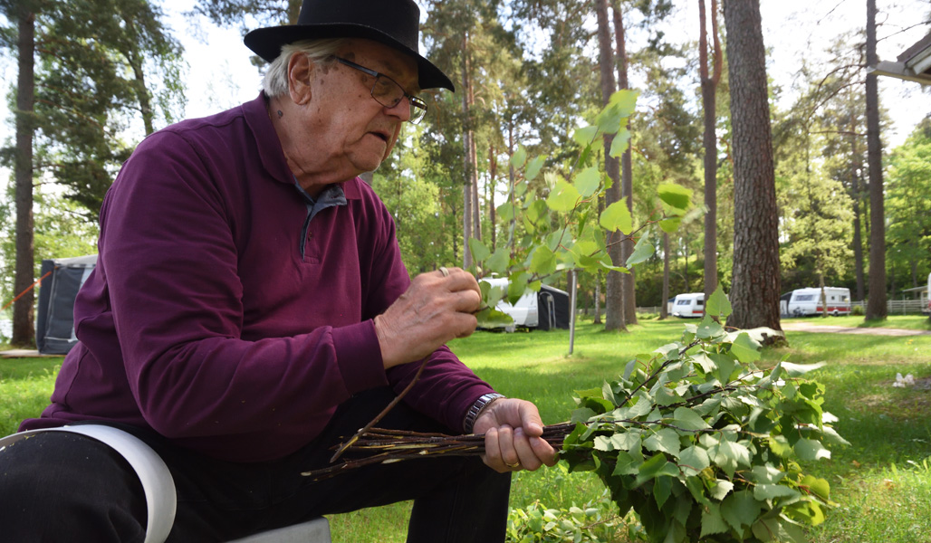 Mies asettelee koivunoksia vihtaan